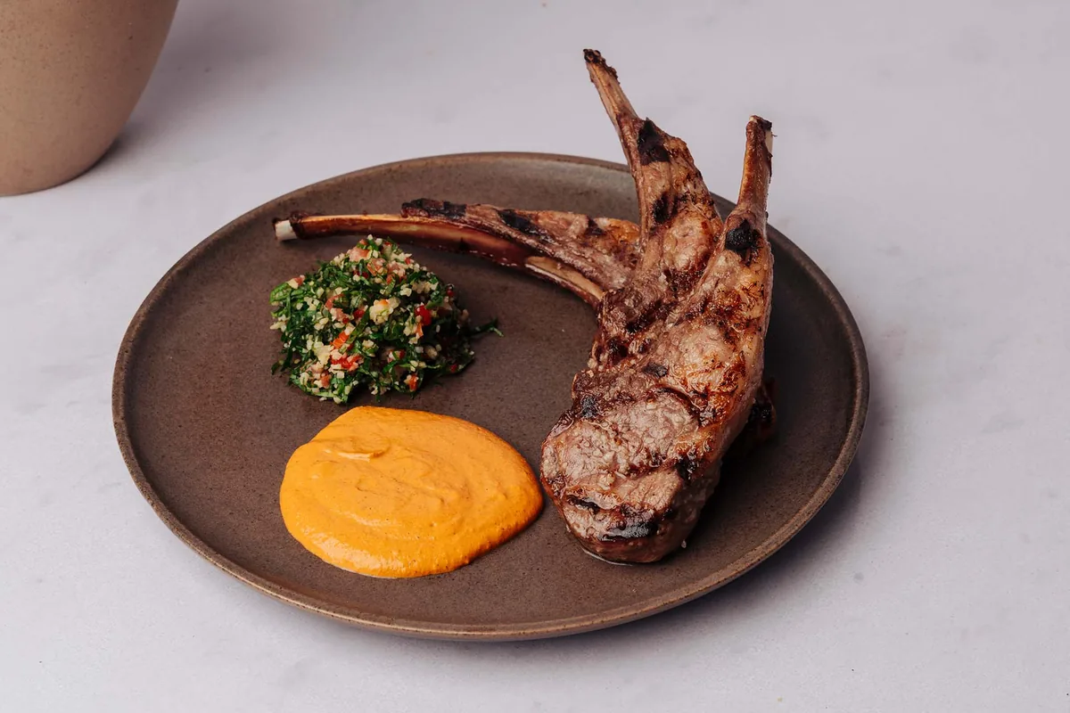 Grilled meat with herb salad and sauce at Ilios Cancun