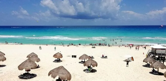 Thatched palapa umbrellas on a white-sand Cancun beach