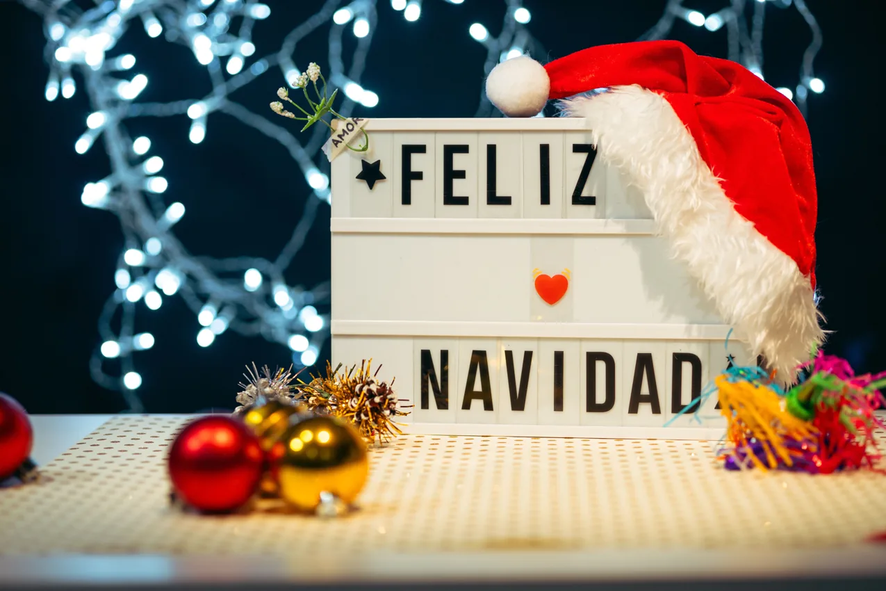 Feliz Navidad sign with a Santa hat, Christmas lights and ornaments