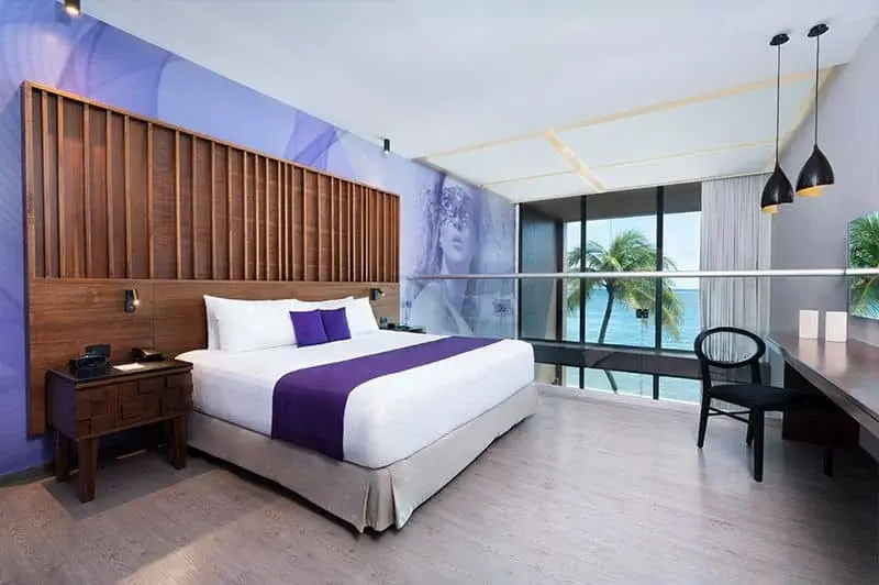 King bed with purple bedding in a Desire suite