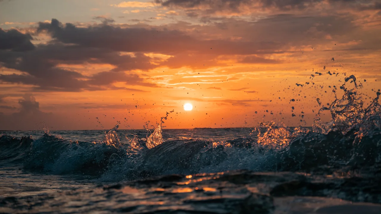 Le coucher de soleil se reflète dans les petites vagues au large d'Holbox.