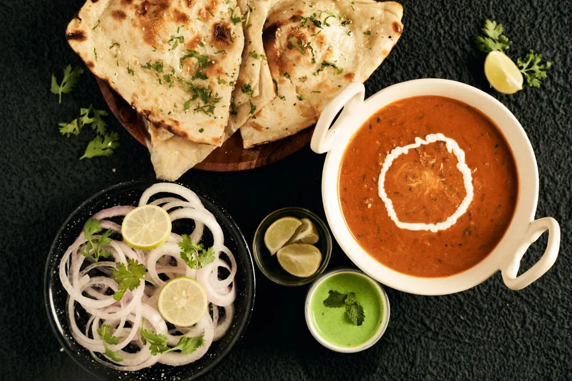Indian curry with flatbread, onion rings and chutney
