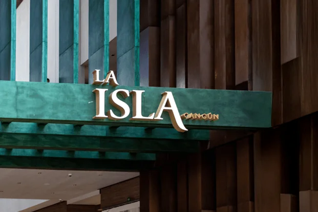 Entrada do centro comercial La Isla Cancun com sua placa e lojas de luxo.