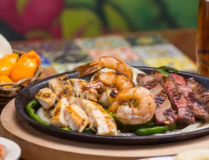 Crevettes, poulet et steak grillés sur un plateau chez La Parrilla Cancun