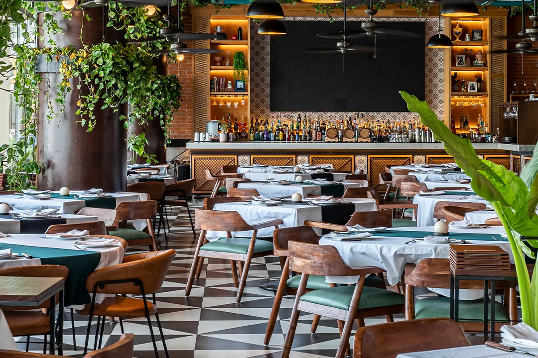 Restaurant tables, patterned flooring and greenery at Marina Puerto Cancun