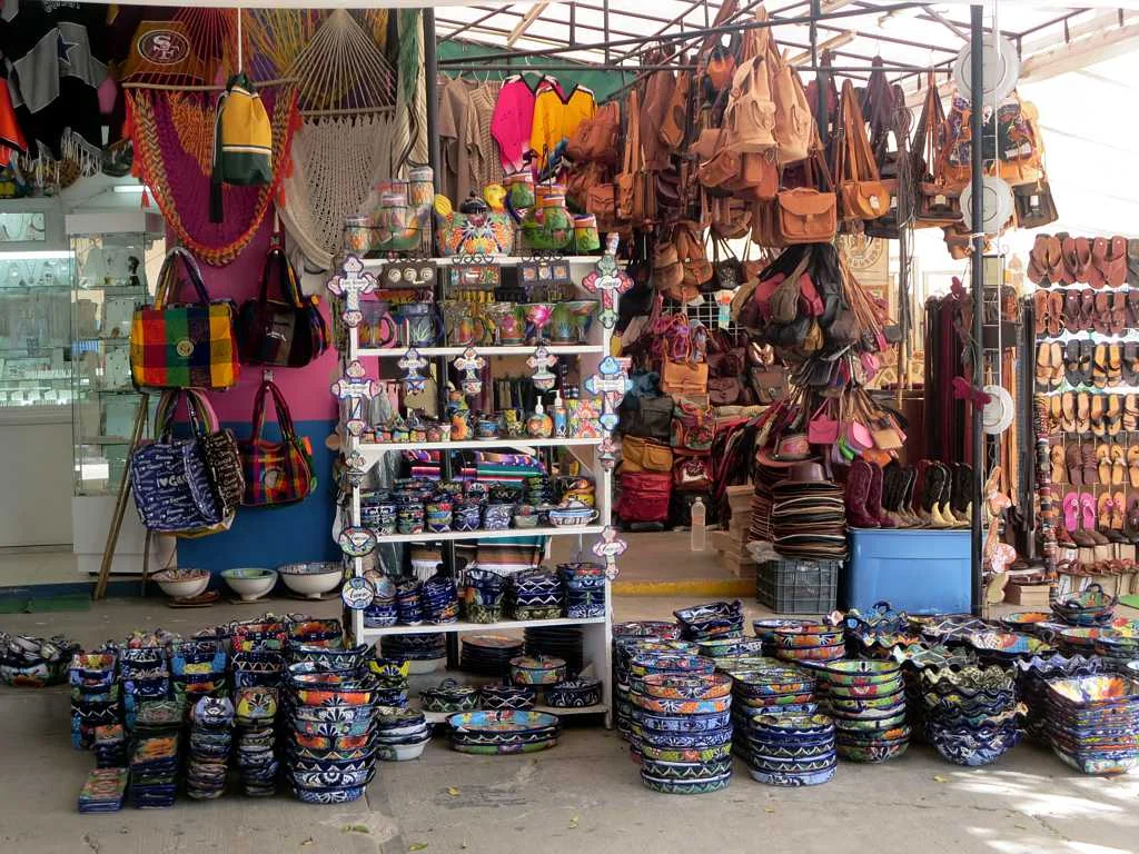 Colorful ceramics, textiles and leather bags at a Mercado 28 souvenir stall