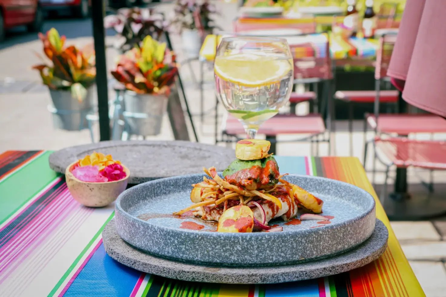 Plated meal and lime drink on a colorful outdoor restaurant table