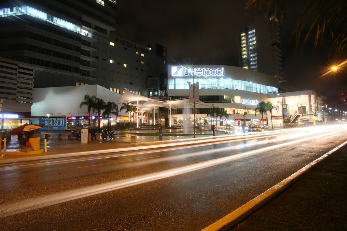 Liverpool e o complexo comercial Malecón Américas iluminados ao lado da Avenida Bonampak em Cancún