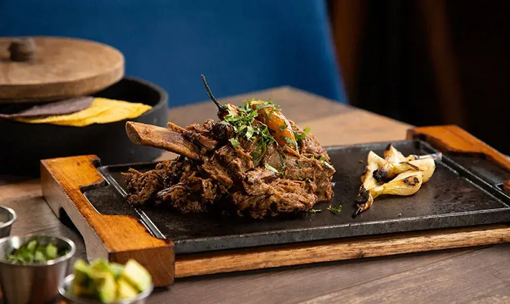 Meat dish served on a hot plate with tortillas at Porfirio’s Cancun