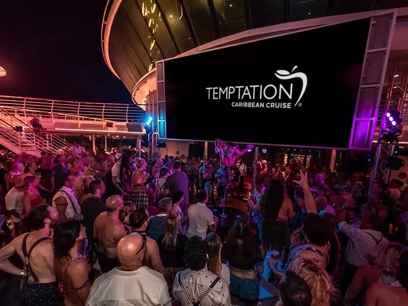 Huéspedes reunidos para una fiesta nocturna en la cubierta durante un crucero anterior del Temptation.