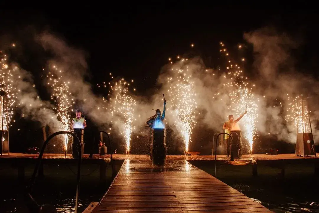 Artistas com fogos de artifício à beira da lagoa no Rosa Negra Cancun