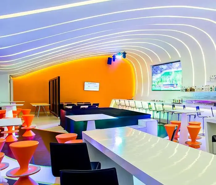 Score sports bar with screens, tables and curved ceiling lighting