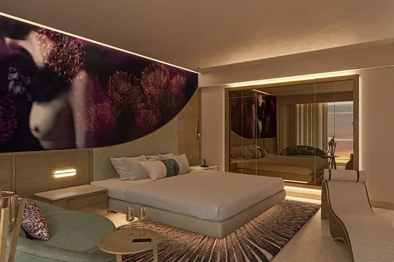 Bed and sofa in a Beloved suite at The Eden