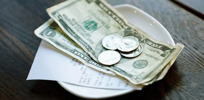 US-dollar bills and coins left as a restaurant tip