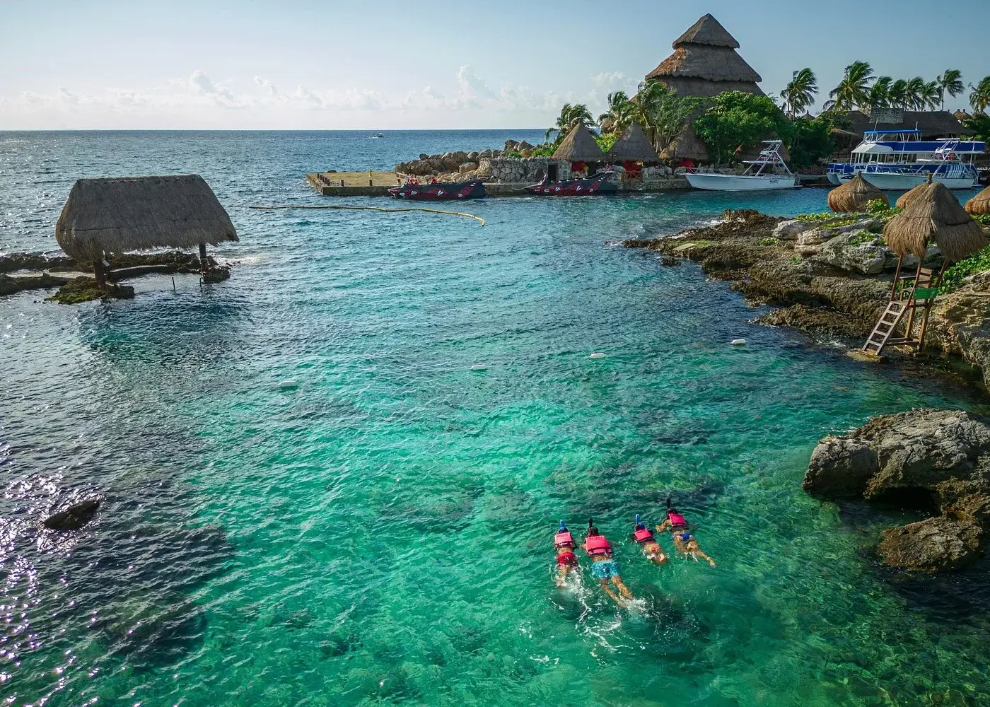 Visitors swimming in Xcaret’s turquoise coastal inlet