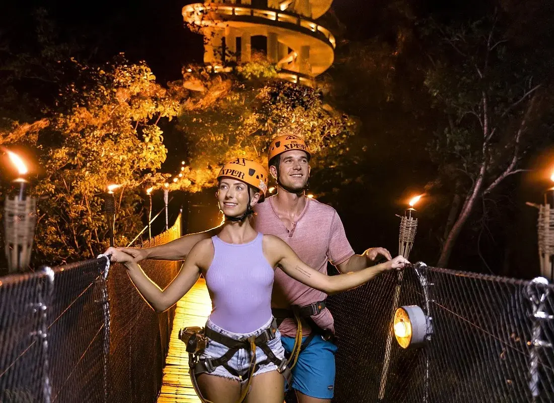 Visitors on a torchlit walkway during Xplor Fuego