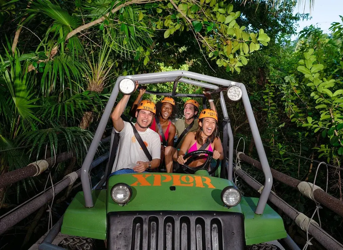 Visitors driving an amphibious vehicle through the jungle at Xplor Park