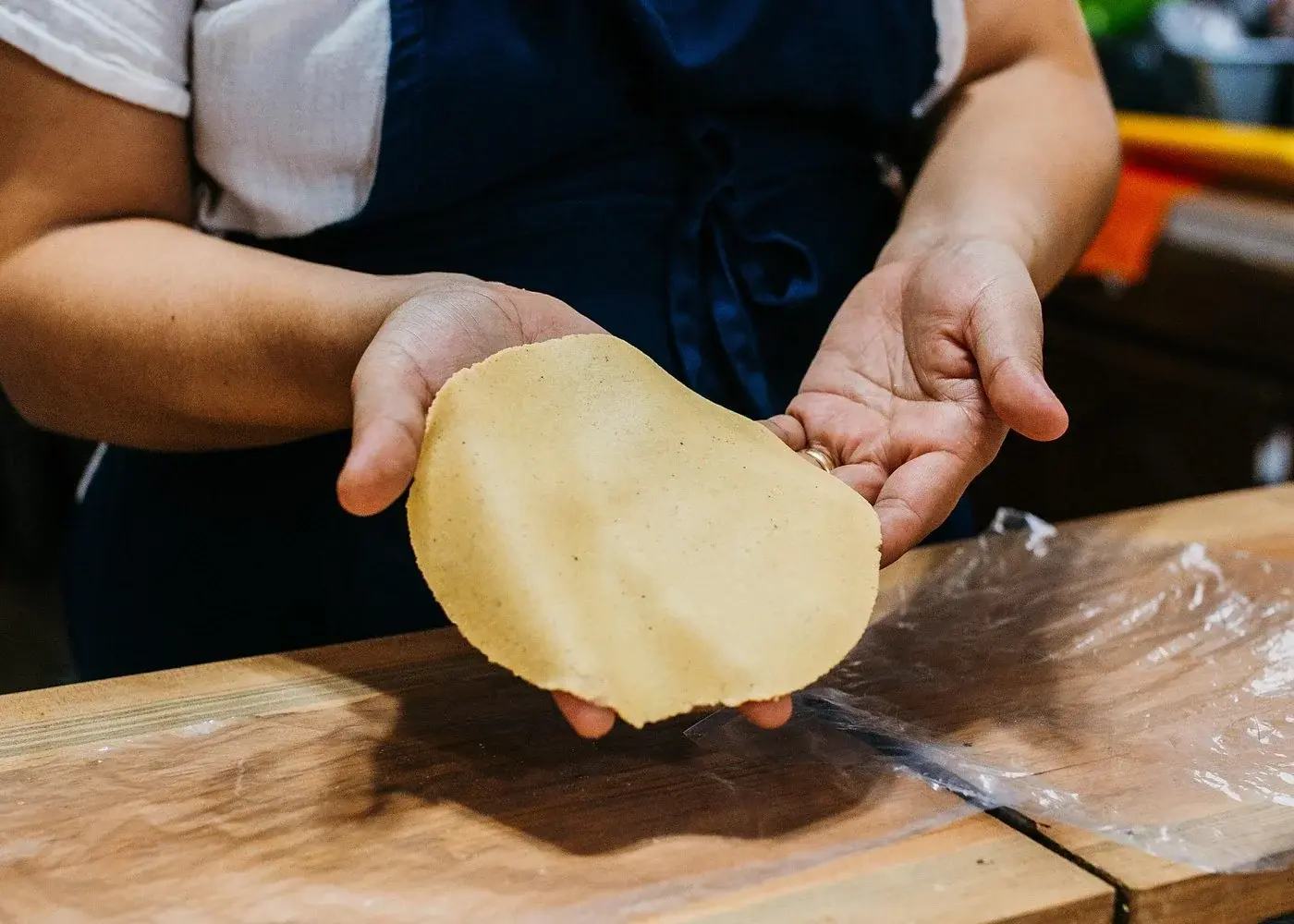 Hands holding a freshly made tortilla during a Playa del Carmen cooking class